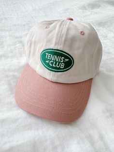 A baseball cap featuring a tennis club embroidery and an adjustable clasp for the perfect fit. Runs large recommended for ages 2+ Kitan Club Hats, Spring Letter Print Baseball Cap For Sports, Trendy Spring Baseball Cap For Sports Events, Spring Sports Baseball Cap With Letter Print, Sporty Baseball Cap With Letter Print For Spring, Sporty Spring Baseball Cap With Letter Print, Casual Snapback Tennis Hat, Sporty Snapback Hat For Tennis, Sporty Snapback Baseball Cap For Tennis