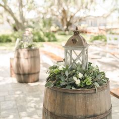 a wooden barrel with flowers and a lantern on top