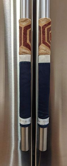 the door handles to a stainless steel refrigerator are decorated with an art deco design and jutting colors