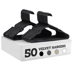 a pair of black velvet hangers sitting on top of a white box