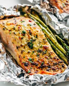 grilled salmon and asparagus in foil on a white plate with text overlay