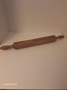 an old wooden rolling pin on display in a box