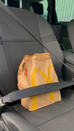 a mcdonald's bag sitting in the back seat of a car next to a pair of scissors