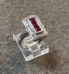 Title: Effy Natural Ruby Diamond 14K White Gold Art Deco Inspired Ring Description: Offering a stunning Art Deco inspired 14K white gold ring by designer Effy. Ring is set with 0.57ct of princess cut natural rubies surrounded by 0.48ct of full cut round brilliant (SI, G-H) diamonds. Gemstones: Rubies (princess cut), Diamonds (full cut round brilliant) Approx. Measurement or Weight of Gem Stones: Rubies: 3 @ 3mm x 3mm x 2.3mm (0.57ct); Diamonds: 32 @ 1.5mm (0.48ct) Color: Rubies: Red, Diamonds: G-H Clarity: SI1-SI2 Mounting metal: 14K white gold Approx. Size or length: Size 5.75, band is 3.5mm wide, design measures 14mm x 8.5mm Condition: Pre owned, very minor wear to metal seen only under 10x magnification, overall excellent condition. Stamping or Factory Markings: 14K and Bita Total weigh 14k White Gold Ruby Ring With Halo Setting, Classic White Gold Ruby Ring With Vvs Clarity, Modern White Gold Ruby Ring For Anniversary, Art Deco White Gold Rings Stamped 14k, White Gold Art Deco Rings Stamped 14k, Modern 14k Stamped White Gold Rings, Luxury Silver Ruby Ring With Polished Finish, Platinum Ruby Ring With Diamond Accents, Modern White Gold Rings Stamped 14k