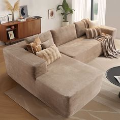 a living room with a large sectional couch in it's center piece and pillows on the back