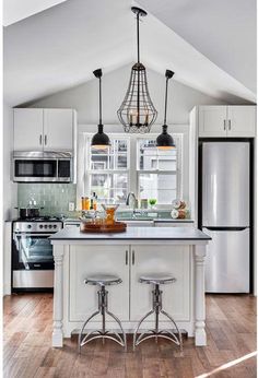 a white kitchen with an island in the middle