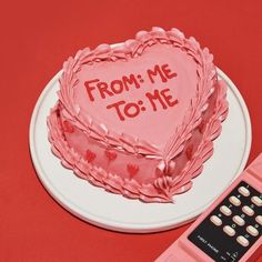 a heart shaped cake sitting on top of a table next to a calculator