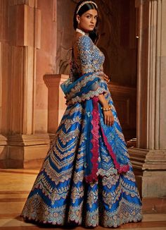 Features the gorgeous peacock blue taffeta lehenga blouse embellished with silver gota, resham and bead work with wine hues. Teamed with a matching blouse and an embellished belt. Completed with tulle dupatta consisting of beautiful gota, resham and beadwork embellishments with a vibrant wine contrast. Composition : Lehenga and Blouse- Taffeta, Dupatta- Tulle Care: Dry Clean Only and Vacuum Storage This product can be customised for sleeves, length of blouse and neckline Delivery : 6-8 weeks as the product is hand crafted. Check Size Guide or choose MySize for free customisation (All Sizes above XL can be made at 15% additional cost) For more information and sizes please contact fabiliciousfashion@gmail.com or visit our Copenhagen studio.About the Designer : Nikita Gujral’s collection of b Traditional Hand Embellished Blue Choli, Blue Hand Embellished Sharara For Reception, Blue Silk Embellished Lehenga, Anarkali Hand Embellished Choli For Navratri, Blue Hand Embellished Choli For Reception, Hand Embellished Tissue Silk Lehenga For Eid, Silk Hand Embellished Choli For Reception, Diwali Hand Embellished Organza Lehenga, Designer Hand Embellished Blue Dupatta