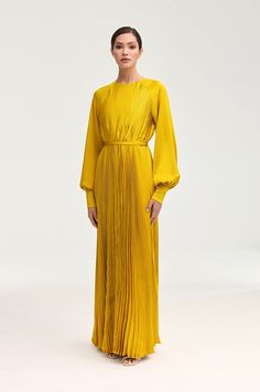 Indulge in luxury and sophistication with our Nadira Satin Pleated Maxi Dress in Honey. The cuffed balloon sleeves and elegant pleats create a timeless silhouette, enhanced by the removable belt. Perfect for any occasion, this dress is destined to make a statement. Model is 5'7" and is wearing size XS/58".