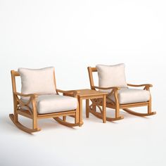 two wooden rocking chairs next to each other on a white background with no one in it