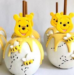 some yellow and white cake pops with winnie the pooh on them