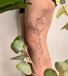 a woman's leg with a tattoo on it and flowers in the bottom half