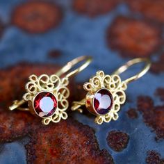 Contessa Earrings: $55+. Choose from pearl, jade, iolite, garnet (shown), onyx, peridot, amethyst, or moonstone crowned with arabesques of filigree to make a showy pair of earrings. 24k gold over sterling silver; hinged backs. 3/4 Inch tall. Elegant Gold Garnet Earrings, Elegant Gold Jewelry With Garnet, Elegant Gold Garnet Jewelry, Elegant Yellow Gold Garnet Earrings, Elegant Pierced Garnet Earrings, Elegant Garnet Jewelry With Filigree Detail, Elegant Garnet Jewelry With Filigree, Elegant Garnet Filigree Jewelry, Gold Garnet Earrings Fine Jewelry