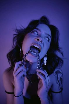 a woman with her mouth open and chains around her neck