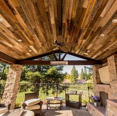 an outdoor covered patio with grill and seating