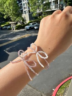 Handmade beaded bracelet featuring a beautiful pink or white bow for the perfect coquette theme. Each bracelet is about 7 inches long. When ordering, primary color refers to the color of the bow. Friendship Bracelet Bead Patterns, Party Jewelry With Pink Bow In White, White Jewelry With Pink Bow For Party, White Party Jewelry With Pink Bow, Adjustable Heart Beads Crystal Bracelet For Party, White Beaded Crystal Bracelet For Party, Adjustable White Bow Jewelry, White Bracelets With Colorful Beads For Party, Pink Letter Beads Bracelet For Party