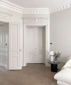 a living room with white walls and wooden floors