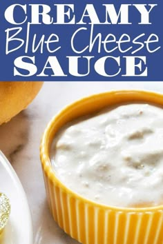 creamy blue cheese sauce in a yellow bowl on a white plate next to some bread