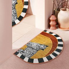 two circular rugs on the floor in front of a vase with flowers and plants