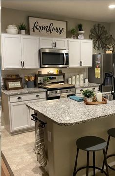 a large kitchen with white cabinets and granite counter tops, an island in the middle