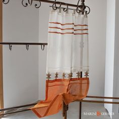 an orange and white curtain hanging on a rail