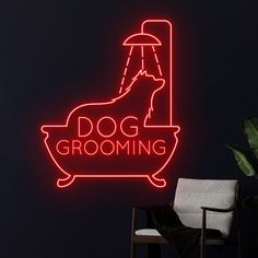 a dog grooming neon sign on the side of a wall next to a chair