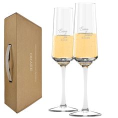 two champagne flutes in front of a cardboard box with the word ombre written on it