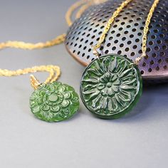 Unique, carved gemstone medallions star in these  gold filled necklaces. Made with delicate woven chain these necklaces feature unique, carved with beautiful floral designs, coin shaped, green Antigorite serpentine. Four available, two with  19mm medallions (options A and B) and two with 25mm medallions  (Option C and D).  Each one of these necklaces looks stylish and elegant, each makes make a statement. These necklaces are to be purchased separately.  Completed with gold filled, lobster claw c Green Necklace With Coin Pendant, Handmade Yellow Gold Round Pendant Medallion Necklace, Handmade Yellow Gold Medallion Necklace With Round Pendant, Spiritual Jade Medallion Necklace, Green Necklace With Coin Pendant As Gift, Green Necklace With Coin Pendant For Gift, Carved Yellow Gold Amulet Jewelry, Handmade Jade Necklace With Flower Pendant, Handmade Jade Flower Pendant Necklace