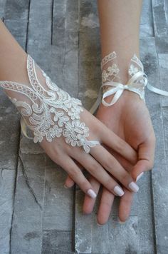 a woman's hands with white lace on them