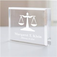 a glass block with the scales of justice on it, and an inscription that reads margaret t klen