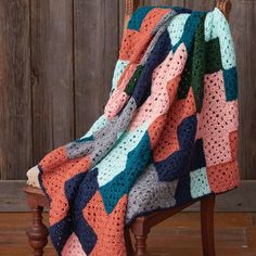 a crocheted blanket sitting on top of a wooden chair