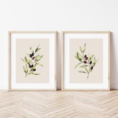 two framed art prints with olives and leaves on the wall next to each other