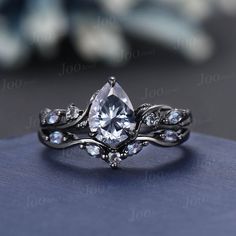 a close up view of a diamond ring on top of a blue cloth with white stones