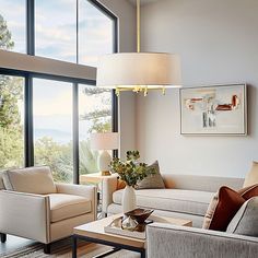 a living room filled with lots of furniture and large windows overlooking the mountains in the distance