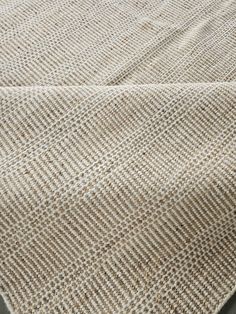 a close up view of a tan and white rug