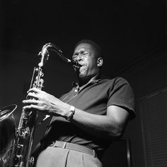 a man that is playing a saxophone in the dark