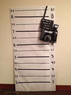 a towel with a camera hanging on it's side next to a wall that is measuring