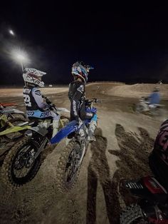 two motorcyclists on dirt track at night