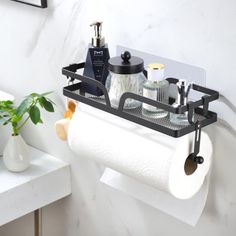 a bathroom shelf with two rolls of toilet paper hanging from it's side and some other items on the wall