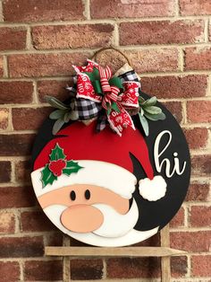 a wooden sign hanging on the side of a brick wall with a santa clause hat