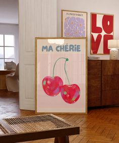 there are two cherries on the table in front of some pictures and a bench