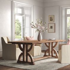 a dining room table with two chairs and a vase on the table next to it