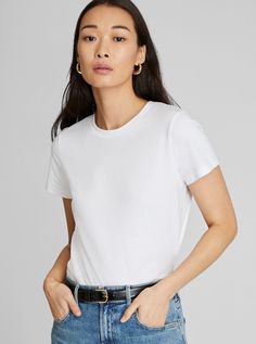 a woman is wearing a white shirt and jeans