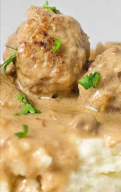 meatballs covered in gravy and garnished with parsley on top