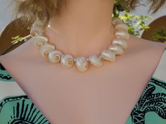 This beautiful necklace are made of pearlized turbo cinerus shells and freshwater pearl beads. Gorgeous and unique! Great idea for gift! 🎁 Necklaces - Length : approximately 16" long, strung with professional quality "Accu-Flex" 49 strands softest drape beading wire. Finished with 18k real gold plated toggle clasp. - Shells : approximately 25mm white turbo cinerus shells and 5mm freshwater pearl. - These are made of natural organic real seashells, blemishes or imperfections are part of its characteristics. - Each natural seashell has its own uniqueness, however, you will receive the same quality seashell as in photo. - Your jewelry will be carefully packaged to ensure safe arrival. Shipping 📦 - I send this order with standard shipping! The estimate delivery date for standard shipping is Pearl Shell Necklace For Gifts, Pearl Shell Necklace For Gift, Pearl White Shell Pearl Necklace As Gift, Shell Beaded Pearl Necklace As A Gift, Handmade Shell Necklaces For Wedding, Elegant White Pearl Necklace From Shell, Elegant Adjustable Beaded Shell Necklaces, Pearl White Shell Necklace As A Gift, Beaded Shell Pearl Necklace Gift