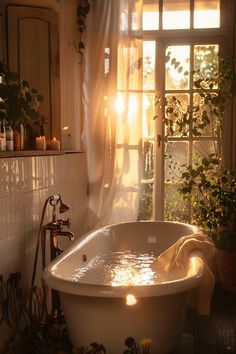 a bathtub in the middle of a bathroom next to a window with sunlight streaming through it