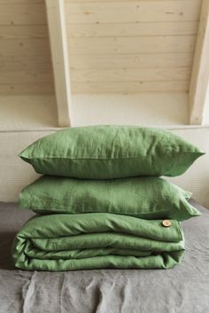 three green pillows stacked on top of each other