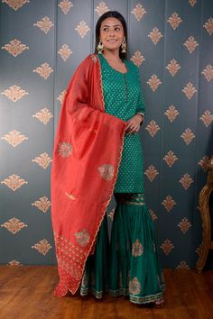 Green kurta with foil print motifs and lace trim on the sleeve hems. Comes with sharara and red chanderi dupatta.
Component: 3
Pattern: Print
Type Of Work: Foil Print
Neckline: Round
Sleeve Type: Three Quarter
Fabric: Kurta: Banarasi Chanderi, Sharara: Cotton Satin and Dupatta: Chanderi
Color: Green
Other Details: 
Printed dupatta with scalloped border
Side slits
Potli button front detailing
Occasion: Wedding - Aza Fashions Designer Wear Sharara With Gota Work For Festive Season, Designer Festive Sharara With Gota Work, Designer Chinon Palazzo Set With Traditional Drape, Designer Wear Traditional Drape Palazzo Set, Designer Palazzo Set With Traditional Drape, Designer Traditional Drape Palazzo Set With Zari Work, Traditional Drape Designer Palazzo Set With Zari Work, Festive Gota Work Sharara In Chinon, Designer Straight Kurta Sharara With Dabka Work