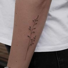 a woman's arm with a small flower tattoo on it