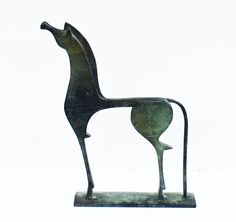 a metal horse sculpture sitting on top of a white surface